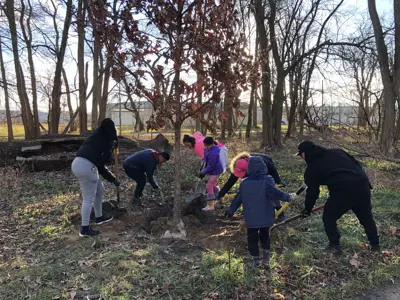 Volunteers planting trees along River Greenway Trail