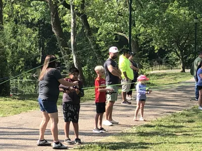 Volunteers teaching kids how to cast at Kids Free Fishing Clinic