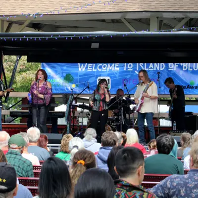 Band performing on stage with the audience enjoying Island of Blues