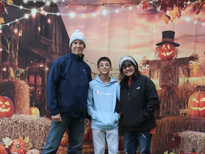 Family posing in front of photo booth at Haunted Walk event