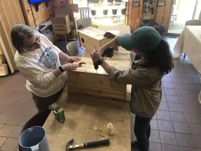 Volunteers helping assemble wood duck box at program at EEC