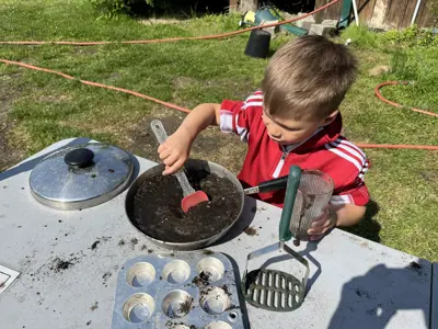 Kid playing in mud kitchen at Nature Play Day program at EEC