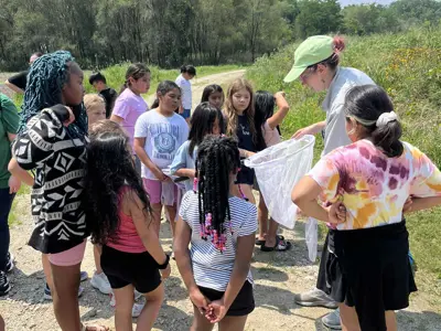 EEC staff showing a butterfly net to students