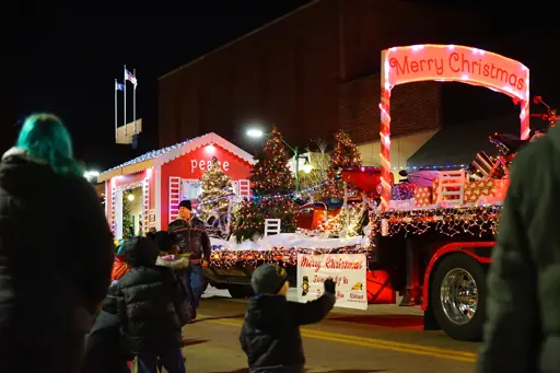 Small boy waving at the Santa float during the Winterfest lighted parade