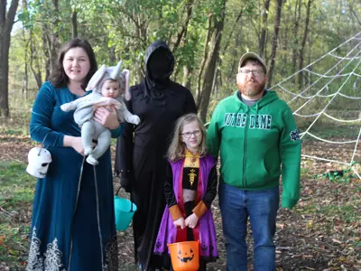 Family in costume on trail at Haunted Walk event