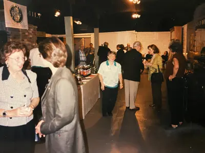 A gala/open house at the museum in the 1990s. Likely taken when the freight houses were opened with new exhibits. People can be seen socializing around a table with refreshments. 